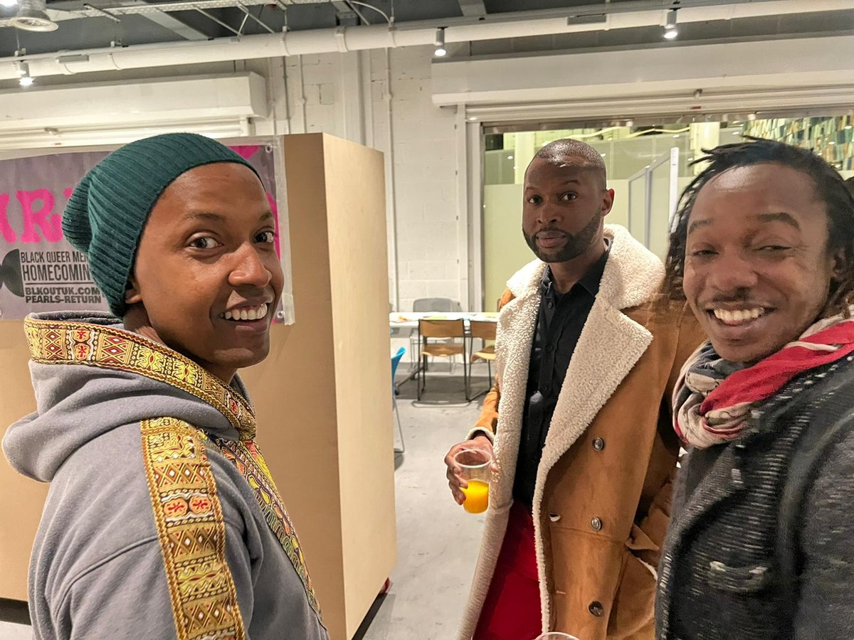 Three members laughing together at a community gathering